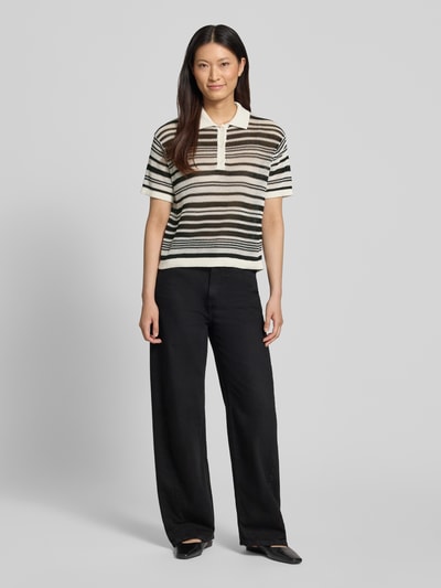 Frauenmodel trägt Regular Fit T-Shirt in Strick-Optik von Comma, Reine Baumwolle, Polokragen, Kurzärmelig, Streifenmuster, Ganzkörperansicht von vorne.