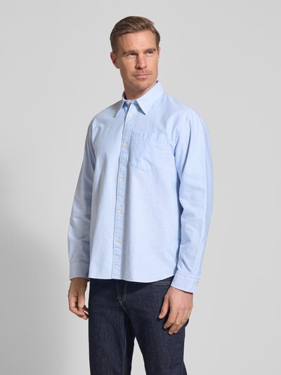 Męski model nosi Relaxed Fit Freizeithemd aus reiner Baumwolle Modell 'OXFORD SHIRT' von Selected Homme, jasnoniebieskie paski, koszula casualowa, krój relaxed fit, kołnierzyk typu kent, listwa guzikowa na całej długości, kieszeń na piersi, długi rękaw, mankiet zapinany na 1 guzik, materiał: bawełna, efekt: wzór w paski, całkowity widok z przodu.