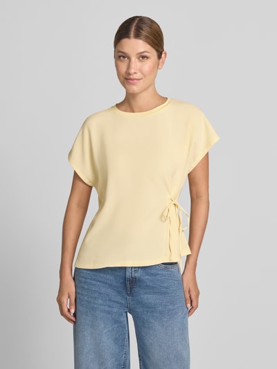 Frauenmodel trägt T-Shirt mit seitlicher Schnürung Modell 'Sifem' von OPUS in zartem Gelb, Regular Fit, Rundhalsausschnitt, glatte Textur, Viskose-Elasthan-Mix, Ganzkörperansicht von vorne.
