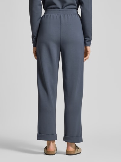 Frauenmodel trägt Sweatpants mit Eingrifftaschen und Aufschlag von Christian Berg Woman, Material-Mix mit Modal-Mix, Relaxed-Fit, Ganzkörperansicht Rückansicht.