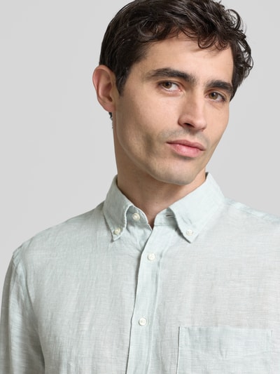 Männermodel trägt Slim Fit Leinenhemd mit Brusttasche von Christian Berg Men, helles Leinen, Button-Down-Kragen, Nahaufnahme Oberkörper.