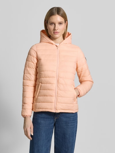 Frauenmodel trägt Steppjacke mit Kapuze Modell 'THELMA' von CARS JEANS, zartes Apricot, Reißverschluss, Eingrifftaschen, Regular-Fit, Ganzkörperansicht von vorne. Rückenlänge bei Größe S: 61 cm, Schulterbreite: 39 cm, Brustweite: 50 cm, Ärmellänge: 62 cm.