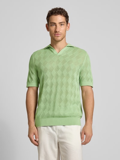 Männermodel trägt Regular Fit Poloshirt aus reiner Baumwolle Modell 'ARCO' von SELECTED HOMME in Hellgrün mit Lochstrickmuster, Ganzkörperansicht von vorne.