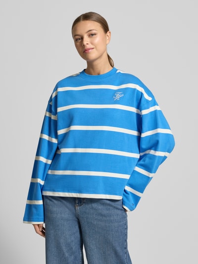 Vrouwenmodel draagt 'Relaxed Fit Sweatshirt aus Baumwoll-Mix' van Tommy Hilfiger met blauw-wit streeppatroon, logostiksel, katoenmix, voorkant totaalbeeld
