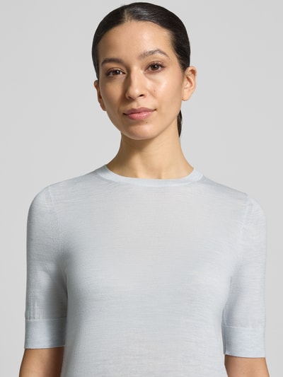 Frauenmodel trägt Strickpullover von BOSS, Modell 'Farbella', Optik: Unifarben, Passform: Shaped Fit, Muster: Gestreift, Kragenform: Crew Neck, Ärmelform: Kurzarm, Ärmelabschluss: Gerippt, Rumpfabschluss: Gerippt, Materialverarbeitung: Feinstrick, Material: Reine Schurwolle. Nahaufnahme Oberkörper.