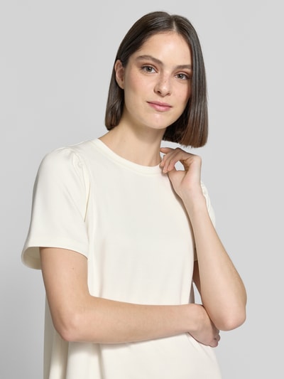 Frauenmodel trägt T-Shirt-Kleid aus Modal-Mix von Rich & Royal in Creme mit Rundhalsausschnitt, Gerader-Schnitt, Nahaufnahme Oberkörper. Rückenlänge 83 cm, Brustweite 40 cm, Ärmellänge 24 cm, Stretch-Anteil, Minikleid.
