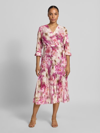 Vrouwenmodel draagt midi-jurk met all-over bloemenprint Model 'Matilda' van ZABAIONE in roze en beige tinten, getailleerde pasvorm, v-hals, 1/2-mouwen, ruglengte maat S 121 cm, borstwijdte maat S 37 cm, mouwlengte maat S 44 cm, geheel lichaamsaanzicht van voren.