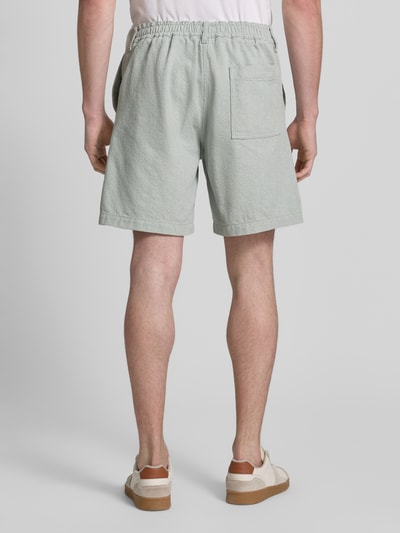 Mężczyzna nosi Regular Fit Shorts aus Baumwoll-Mix model 'SANDREW' od BOSS Orange, efekt: jednolity kolor, wykończenie: splot twill, naszywka z logo, kieszeń z tyłu, wpuszczane kieszenie boczne, szlufki na pasek, zapięcie na guzik i kryty zamek błyskawiczny, mieszanka bawełny; widok całej sylwetki z tyłu.