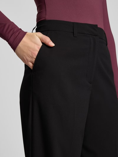 Frauenmodel trägt Bundfaltenhose mit Viskose-Anteil Modell 'ROSA' von Pieces, unifarben, Wide Leg, High Waist, Nahaufnahme Oberkörper.