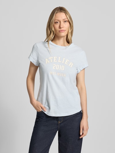 Frauenmodel trägt Regular Fit T-Shirt mit Logo-Print von MOS MOSH aus Reine Baumwolle, hellblau mit feinen Streifen, Rundhalsausschnitt, Rückenlänge bei Größe S 63 cm, Ganzkörperansicht von vorne.