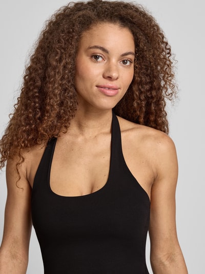 Frauenmodel trägt figurbetontes Neckholder-Top mit Rundhalsausschnitt von REVIEW aus Baumwoll-Elasthan-Mix, Slim-Fit, Nahaufnahme Oberkörper. Rückenlänge bei Größe S: 32 cm.