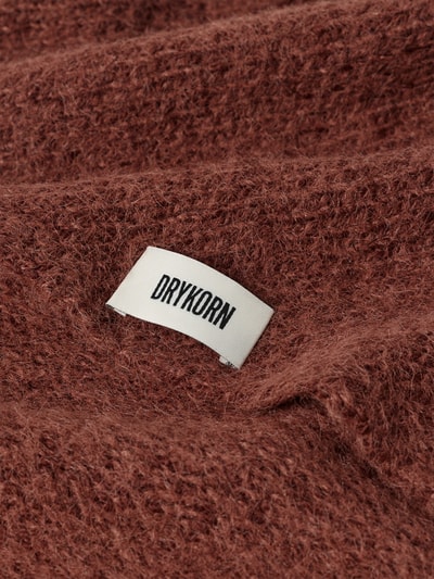 Produktfoto, Dreieckstuch mit Woll-Anteil von DRYKORN in rötlich-brauner Strick-Optik, sichtbarer Label-Patch, Material-Mix, Detailaufnahme.