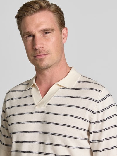 Männermodel trägt Regular Fit Poloshirt aus reiner Baumwolle von Tom Tailor in Beige mit dunkelblauen Streifen, Nahaufnahme Oberkörper.