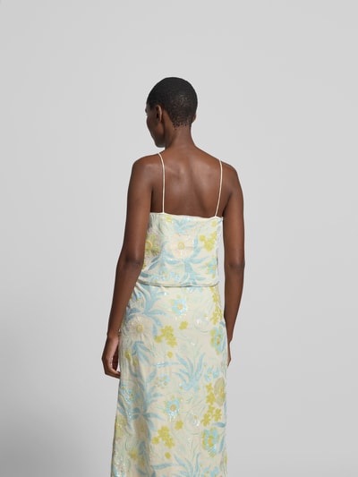 Frauenmodel trägt Top mit Allover-Paillettenbesatz von BAUM & PFERDGARTEN, florales-Muster, Elastischer-Material-Mix, Regular-Fit, Spaghetti-Träger, Rückenlänge 25 cm bei Größe S, sanfte Gelb- und Blautöne, glänzende Textur, Ganzkörperansicht Rückansicht.