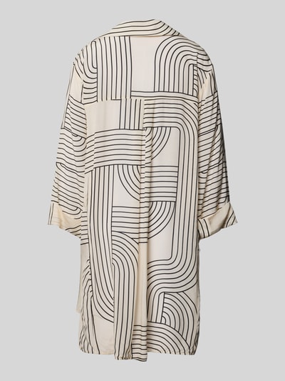 Frauenmodel trägt Relaxed Fit Bluse aus Viskose von WATERCULT, cremefarben mit schwarzem Allover-Linienmuster, Hemdblusenkragen, Ganzkörperansicht Rückansicht.