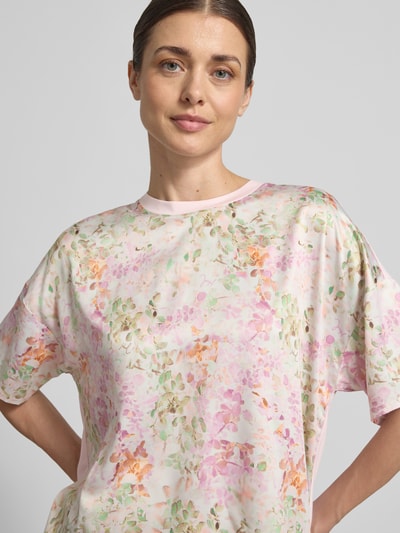 Kobiece modelka ma na sobie damski t-shirt T-Shirt aus Viskose-Elasthan-Mix model 'Tracy' od JOOP!, wzór na całej powierzchni, okrągły dekolt, krój regular fit, długość tyłu w rozmiarze 36: 61 cm, pastelowe kolory, bladoróżowe i zielone odcienie, miękka tekstura, zbliżenie na górną część ciała.