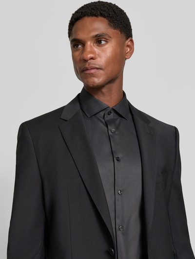 Männermodel trägt Slim Fit Businesshemd in Premiumqualität mit extra langem Arm von Jake*s, schwarzes Allover-Muster, Nahaufnahme Oberkörper