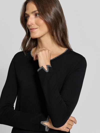Frauenmodel trägt Pullover aus Viskose-Mix Modell 'Maglia Chiusa' von Liu Jo White in Schwarz mit silberfarbenen Akzenten, Nahaufnahme Oberkörper. Damen Pullover, körpernahe Passform, Rundhalsausschnitt, langärmelig, Rückenlänge 60 cm, Ärmellänge 64 cm.