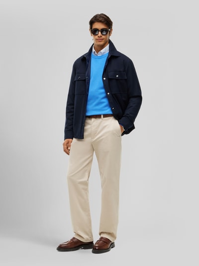 Mannenmodel draagt Regular Fit Pullover uit zuivere katoen van Tommy Hilfiger, felblauw, gecombineerd met lichtbeige broek, geheellichaamsvooraanzicht.