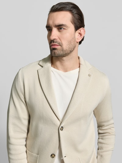 Männermodel trägt Slim Fit 2-Knopf-Sakko mit Reverskragen von Manuel Ritz aus reiner Baumwolle in Beige, Nahaufnahme Oberkörper.