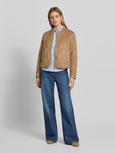 Vrouwenmodel draagt Jacke mit Stehkragen und Zweiwege-Reißverschluss van Fuchs Schmitt in regular fit met doorgestikte naden, opstaande kraag en tweewegritssluiting, camel-bruin, gecombineerd met blauwe jeans en blauwe blouse, ruglengte bij maat 36: 57 cm, schouderbreedte: 47 cm, borstwijdte: 43 cm, mouwlengte: 67 cm. Ganzkörperaanzicht van voren.