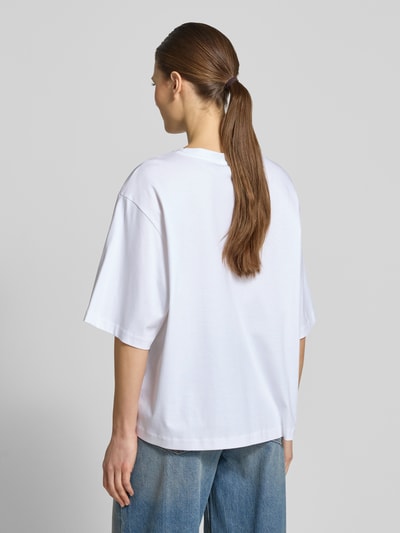 Vrouwenmodel draagt oversized T-shirt met ronde hals model 'PINARA' van Drykorn, puur katoen, ruglengte bij maat S 61 cm, volledige rugaanzicht.