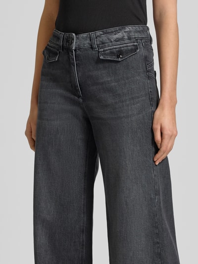Kobiece modelka nosi Wide Fit Jeans mit Gesäßtaschen od Luisa Cerano, czarny dżins, elastyczny bawełniany materiał, patki, zapięcie na guzik i zamek, szerokość w rozmiarze 36: 40 cm, długość nogawki wewnętrznej w rozmiarze 36: 86 cm, zbliżenie na górną część ciała