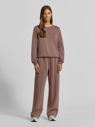 Vrouwenmodel draagt Wide Fit broek uit viscosemix met elastische band en steekzakken van Liu Jo, kleur effen oudroze, Dames, ganzichaansicht van voren. Context: Binnenbeenlengte bij maat S is 79 cm.