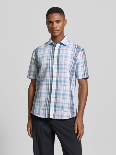 Männermodel trägt Slim Fit Business-Hemd aus Leinen-Mix mit Kentkragen von Jake*s, kariertes Muster in Blau-Weiß, Ganzkörperansicht von vorne. Kontext: Leinen-Baumwoll-Mix, Knopfleiste, Rückenlänge 74 cm, Schulterbreite 46 cm, Ärmellänge 26 cm.