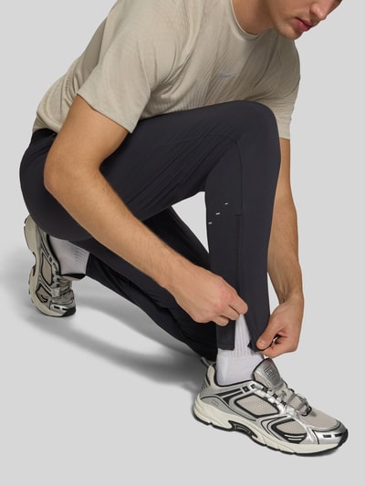 Männermodel trägt Slim Fit Trainingshose mit Dri-FIT-Technologie Modell 'Stride' von Nike aus der Herren Trainingshose von Nike Training, Nahaufnahme Unterkörper.