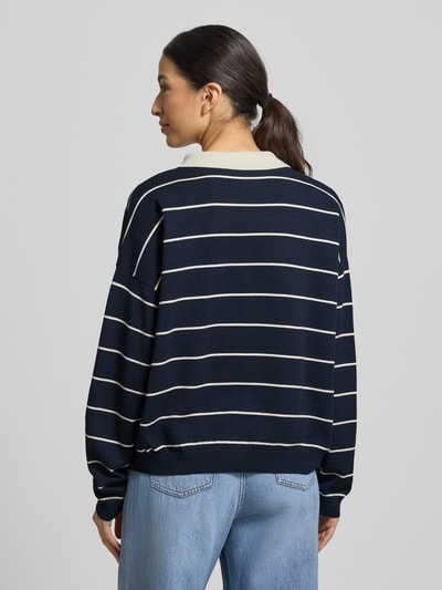 Frauenmodel trägt Strickpullover mit Polokragen Modell 'taige' von Gestuz, navy mit weißen Streifen, Oversized, Rückenansicht Ganzkörperansicht.