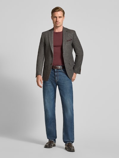 Männermodel trägt Slim Fit Sakko mit Viskose-Anteil Modell 'Theo' von Carl Gross, grau, Strukturstoff, Ganzkörperansicht von vorne.