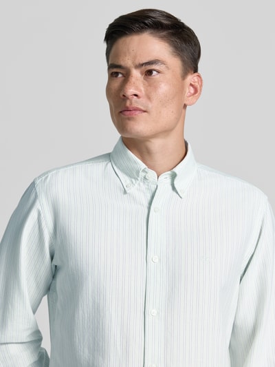 Männermodel trägt Regular Fit Freizeithemd aus Lyocell-Baumwoll-Mix Modell 'RICOPLUS' von BOSS Orange, gestreift, Nahaufnahme Oberkörper.