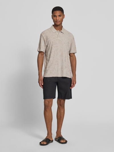 Männermodel trägt Regular Fit Poloshirt aus Baumwoll-Mix Modell 'PE_FLOWER' von BOSS Orange mit Allover-Muster und Struktur, Ganzkörperansicht von vorne.