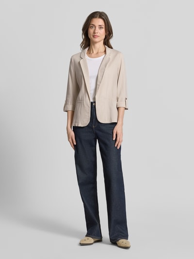 Vrouwenmodel draagt Loose Fit Kurzblazer aus Viskose-Leinen-Mix Modell 'JESMILO' van Vero Moda, look: effen, pasvorm: loose fit, reverskraag, zonder sluiting, mouwvorm: 3/4-mouw met vaste omslag, met paspelzakken als detail, materiaalverwerking: gevlamd garen, materiaal: mix van viscose en linnen, lichte beige kleur, rechte vormen, gladde textuur, voorkant van het hele lichaam.