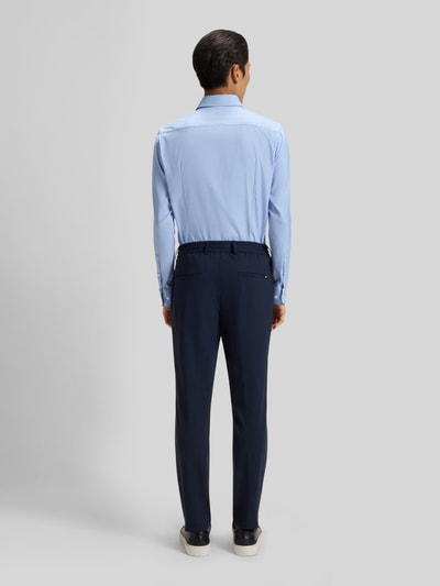 Männermodel trägt Slim Fit Businesshemd aus Stretch-Twill Modell 'P-HANK-KENT-C1-222' von BOSS in Hellblau, einfarbig, Ganzkörperansicht Rückansicht.