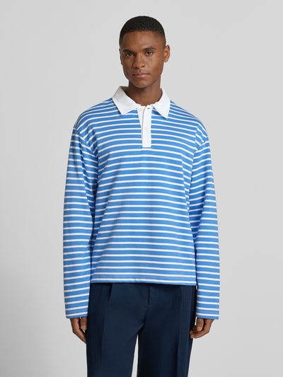 Męski model trägt Relaxed Fit Koszulka polo z listwą guzikową Model 'PERSSON' od Casual Friday, mieszanka bawełny i wiskozy, stylizacje casualowe, długość tyłu dla rozmiaru M: 66 cm, niebieskie paski, z długim rękawem, Ganzkörperansicht von vorne.