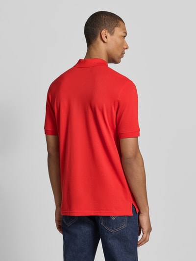 Männermodel trägt Regular Fit Poloshirt mit Stitching von Christian Berg Men, reine Baumwolle, rote Farbe, Rückenlänge 70 cm, Ganzkörperansicht Rückansicht.