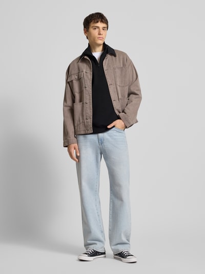 Mannenmodel draagt Loose Fit Sweatshirt aus Baumwoll-Mix van Tommy Jeans in uni optiek, met logo-stitching, sweat katoenmix, troyerkraag, geribde boorden, lange mouwen, dropped shoulders, Ganzkörperansicht van voren.