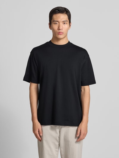 Männermodel trägt Regular Fit T-Shirt aus Baumwoll-Mix Modell 'TEETIM' von BOSS Orange, Optik: Unifarben, Label-Print, Rundhals, Ganzkörperansicht von vorne.
