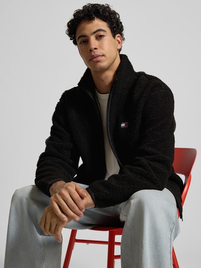 Männermodel trägt Relaxed Fit Fleecejacke in Teddyfleece-Optik von Tommy Jeans, Optik: Unifarben, Stehkragen, Reißverschluss, Ganzkörperansicht von vorne.