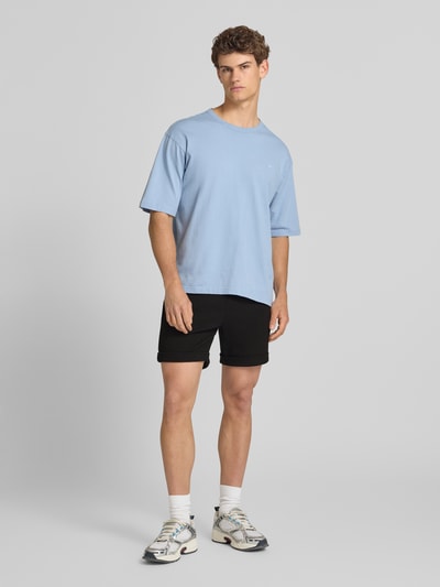 Männermodel trägt Regular Fit Shorts mit Viskose-Anteil Modell 'NEWKODYL' von Only & Sons, Melange-Optik mit Nadelstreifen, fixierter Umschlag, Eingrifftaschen, elastischer Bund mit Tunnelzug, Gesäßtasche, Ganzkörperansicht von vorne.