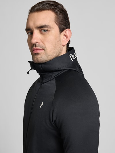 Männermodel trägt Slim Fit Jacke mit Logo-Print Modell 'Rider' von Peak Performance im Elastischer-Material-Mix, Nahaufnahme Oberkörper.