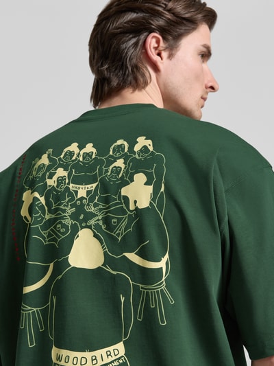 Mężczyznamodel nosi t-shirt z bawełny ekologicznej Woodbird T-Shirt mit Label-Detail Modell 'Beam', luźny krój, detal z logo, długość tyłu 71 cm w rozmiarze M, widok na plecy