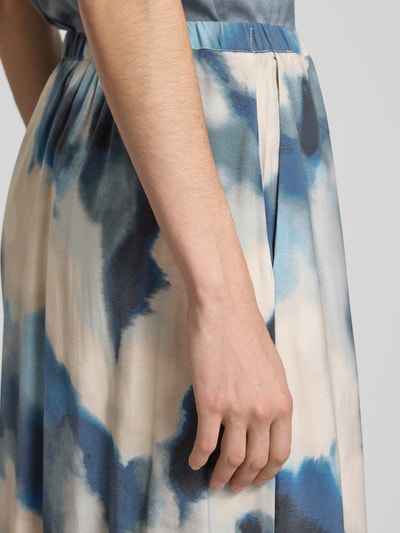 Frauenmodel trägt Midirock aus Viskose-Mix Modell 'Aveline' von mbyM, Allover-Look in Blau und Beige, Nahaufnahme Oberkörper. Bundweite bei Größe S: 37 cm, Gesamtlänge bei Größe S: 86 cm.