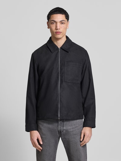 Männermodel trägt Regular Fit Jacke in Lederoptik Modell 'RICK' von Only & Sons, unifarben schwarz, Umlegekragen, Ganzkörperansicht von vorne.