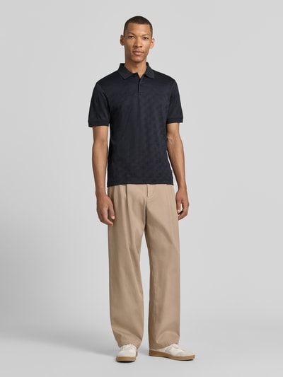 Männermodel trägt Modern Fit Poloshirt mit Strukturmuster Modell 'Roberto' von JOOP! Collection aus reiner Baumwolle in Dunkelblau, mit Polokragen, kurzer Knopfleiste und Label-Detail, Rückenlänge 68 cm bei Größe M, Ganzkörperansicht von vorne.
