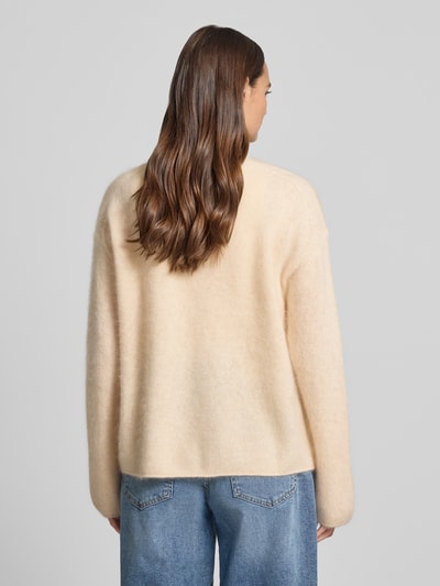 Kobiece modelka nosi Relaxed Fit Cardigan aus Kaschmir-Mix od HERZENS w kolorze jasnego beżu, tekstura dzianinowa, długość tyłu 61 cm, długość rękawa 54 cm, widok całopostaciowy z tyłu.