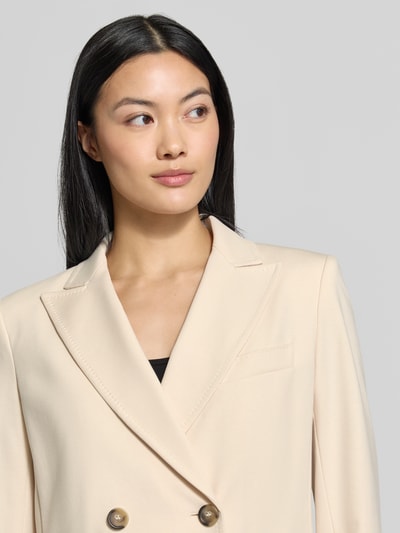 Frauenmodel trägt Regular Fit Longblazer mit doppelter Knopfleiste Modell 'WKDCOLIBRI' von Weekend Max Mara in Beige, Nahaufnahme Oberkörper.