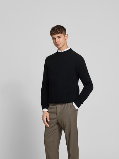 Männermodel trägt Pullover aus Woll-Mix mit Yak-Anteil von Filippa K in Schwarz, Slim Fit, Strick-Optik, Ganzkörperansicht von vorne.